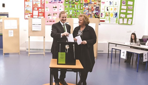 Irish Prime Minister Enda Kenny stands with his wife Fionnuala as he casts his vote in a polling station at St Anthonyu2019s School in Castlebar, Ireland, yesterday.