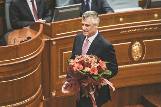 Thaci holds a bouquet during an extraordinary session in Pristina after the foreign minister and former premier was elected as president.