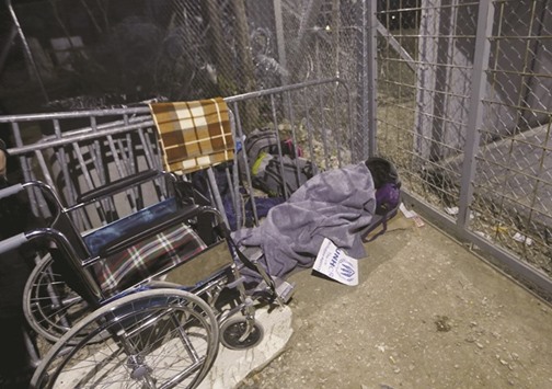 Zhino Hasan, 17, is seen in front of the closed Idomeni border gate.
