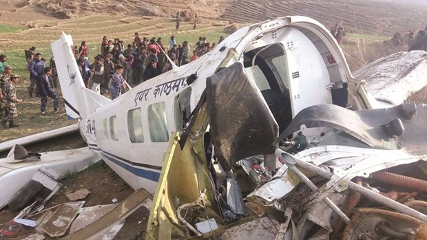 A small plane operated by Kasthamandap Airlines is seen on a field after it crashed in Kalikot.