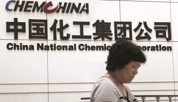 A woman checks her phone at the headquarters of ChemChina in Beijing. Chinau2019s state-owned firm has received so many offers of funding for the Syngenta deal, including from private equity investors and banks, chairman Ren Jianxin said yesterday.