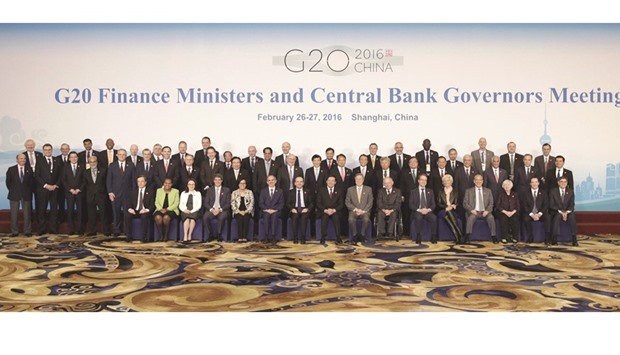 Attendees pose for a group photo during the G20 finance ministers and central bank governors meeting in Shanghai. Finance chiefs agreed to consult closely on foreign exchange markets and reiterated past pledges to refrain from competitive devaluations.