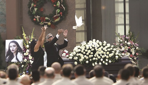 Parents of San Bernardino shooting victim Yvette Velasco, Marie and Robert Velasco release a white dove over her casket during memorial service in Covina, California (file). Apple argues that the Justice Department is overstepping its authority by forcing the company to help disable the encryption on an iPhone used by one of the two shooters who killed 14 people at a holiday party in San Bernardino on December 2