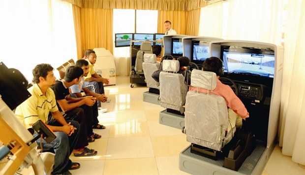 Students practice on simulators at a driving school