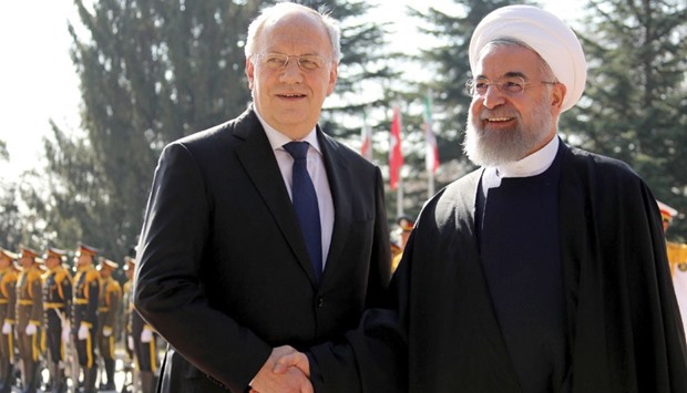 Iranian President Hassan Rouhani, right, shakes hands with his Swiss counterpart Johann Schneider during an official welcoming ceremony following the latteru2019s arrival for talks, in Tehran yesterday.