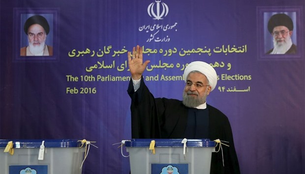 Iranian President Hassan Rouhani waves after casting his vote during elections for the parliament and Assembly of Experts, which has the power to appoint and dismiss the supreme leader, in Tehran on Friday.