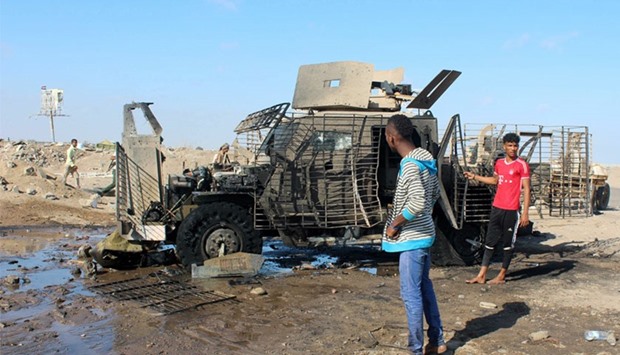 Yemenis inspect a burnt armored vehicle after a suicide bomber rammed his explosives-laden vehicle into an area where security forces and pro-government militiamen had assembled. AFP