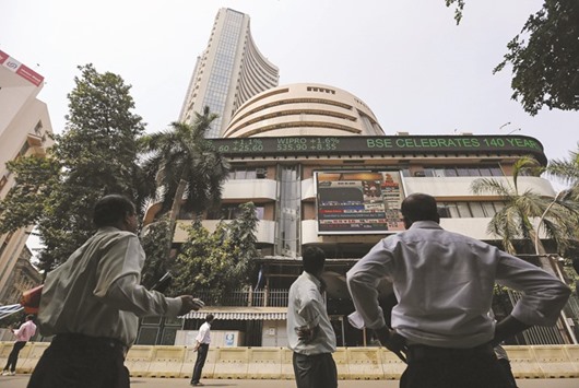 People look at a screen displaying Indiau2019s Finance Minister Arun Jaitley presenting the budget, on a facade of the Bombay Stock Exchange building in Mumbai. The Sensex closed down 0.6% to 23,002 points yesterday, after changing direction at least 15 times.