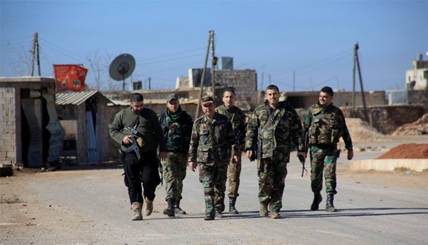 Syrian government forces walk in the village of Tal Jabin, north of the embattled city of Aleppo, as they advanced to break a three-year rebel siege of two government-held Shiite villages, Nubol and Zahraa, and take control of parts of the supply route.