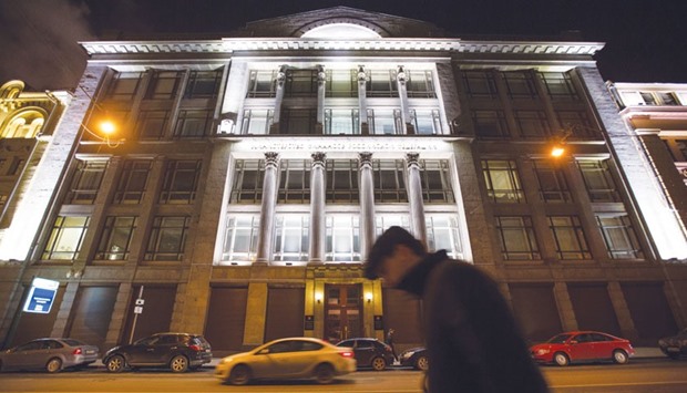 A pedestrian passes the headquarters of Russiau2019s ministry of finance in Moscow. The ministry has said it wants to raise about $12.5bn by selling stakes in state companies over two years.