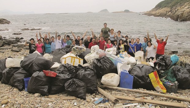 Volunteers posing with all the rubbish collected and bagged for removal at a beach in Hong Kong. The city is suffocating under a film of plastic: u201cEach day the equivalent weight of two A380 Airbus planes is discardedu201d in domestic waste, says Lisa Christensen, co-founder of HK Clean Up initiative.