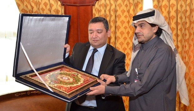 Hikmatullozoda presents a souvenir to al-Shaibei following his meeting with the QIIB chief executive yesterday.