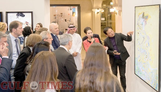 ALL EYES, AND EARS: Lee Lee Nam explains the finer points of an art piece to dignitaries and enthusiasts.