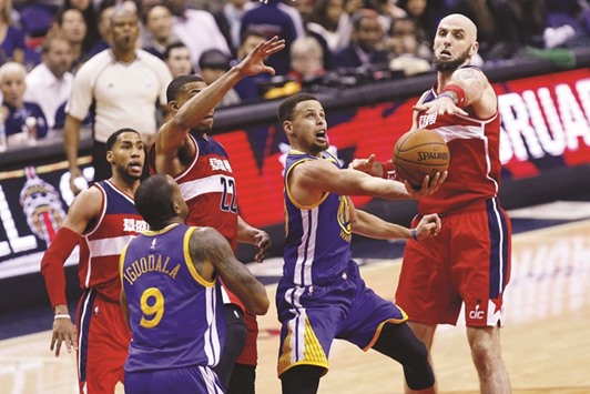 Washington Wizards center Marcin Gortat (right) attempts to block the shot of Golden State Warriors guard Stephen Curry (second right) in the third quarter in Washington. (USA TODAY Sports)