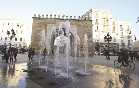 People walk past the arch of Bab el-Bhar, also known as the French gate, in Tunis yesterday.