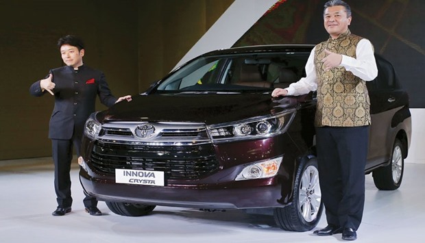 Managing director of Toyotau2019s India unit Naomi Ishii and chief executive engineer Hiroki Nakajima (right) pose with their new Innova car during its launch at the Indian Auto Expo in Greater Noida, on the outskirts of New Delhi on Wednesday.