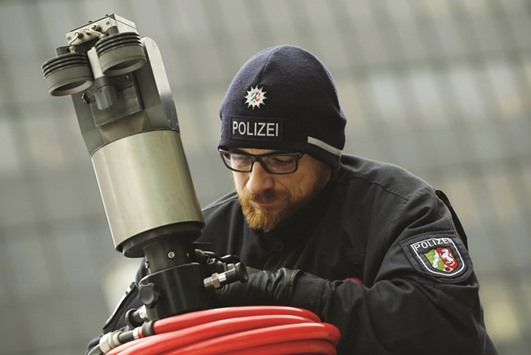 A police officer sets up a mobile surveillance camera during u2018Weiberfastnachtu2019 (Womenu2019s Carnival) celebrations in front of the main station in Cologne.