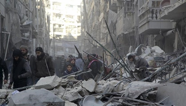 Residents inspect damage after airstrikes by pro-Syrian government forces in the rebel-held Al-Shaar neighbourhood of Aleppo on Thursday.