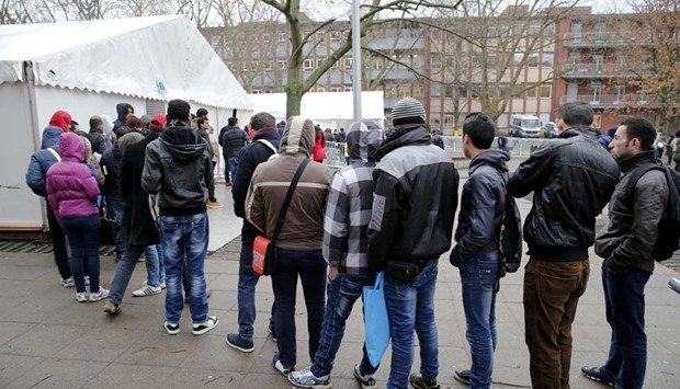 Migrants queue in front of the compound of Berlin Office of Health and Social Affairs (LAGESO) for their registration process in Berlin on Friday.
