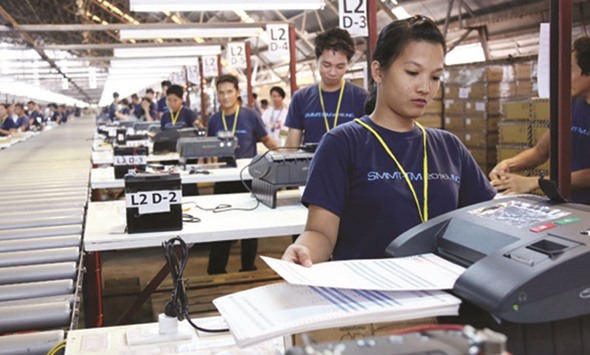 Workers test the accuracy of the vote counting machines delivered by Smartmatic.