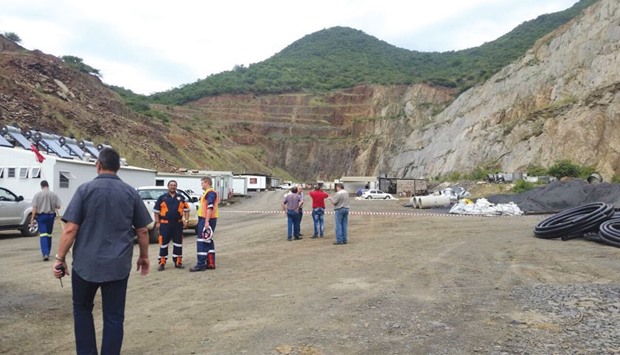 Rescue workers and vehicles stand by at the scene of the mine collapse near Barberton. Seventy-five rescued miners were brought to the surface yesterday, police said.