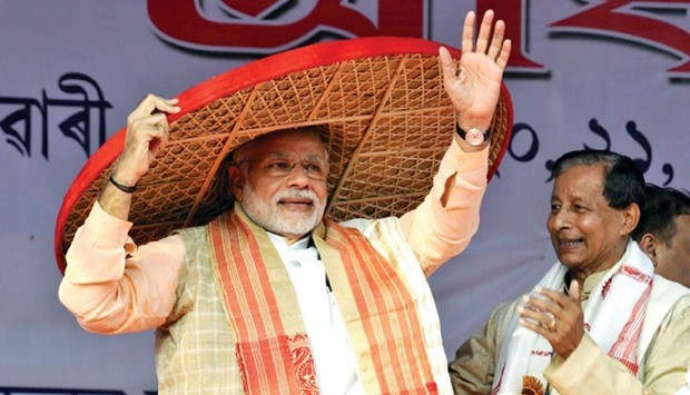 Prime Minister Narendra Modi being presented Jaapi, a traditional hat from Assam, at the 85th Annual Conference of Srimanta Sankaradeva Sangha in Sibasagar, Assam on Feb 5, 2016.