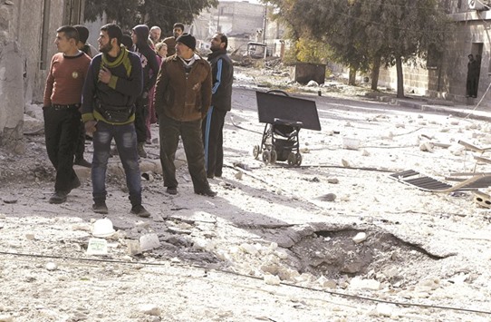A group of people inspecting the damage after air-strikes by Syrian regimeu2019s forces in the rebel held al-Sakhour neighbourhood of Aleppo yesterday.