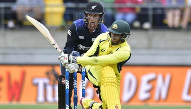 Usman Khawaja (front) of Australia plays a shot watched by Luke Ronchi keeper for New Zealand