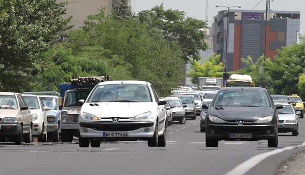 The file photo taken on July 24, 2012 shows Iranians driving locally-manufactured Peugeot 206 cars in the streets of Tehran. Peugeot suspended sales in Iran in 2012 when the international sanctions against the countryu2019s nuclear programme were extended to the automobile sector.