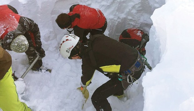 Rescue team members search for people buried yesterday by an avalanche at the Wattener Lizum, Austria.