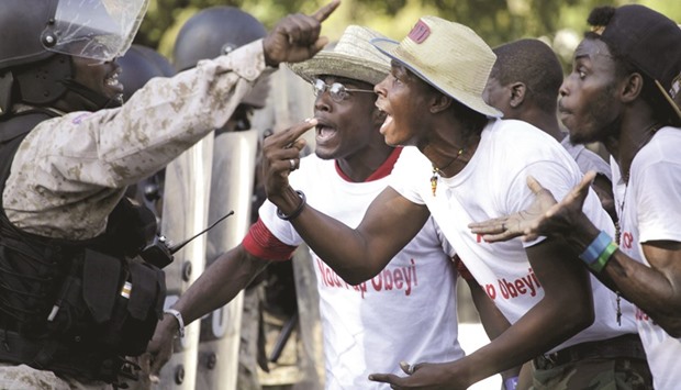 Opposition protesters argue with a National Police officer during a demonstration in Port-au-Prince on Friday.