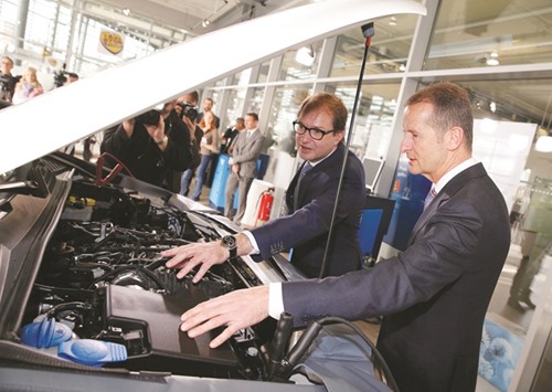 Herbert Diess (right) chairman of Volkswagenu2019s passenger cars brand and German Transport Minister Alexander Dobrindt (2nd right) inspect the engine of an Amarok car during Volkswagenu2019s diesel-emissions software update at a VW dealer in Berlin on February 2. The car maker has still not decided whether vehicle owners in the US will be offered cash, car buy-backs, repairs or replacement cars.