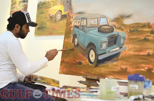 WIDE CANVAS: Al-Maadheed working on his latest painting at Souq Waqif Art Gallery.     Photos by Anand Holla