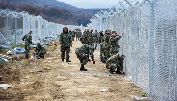 Macedonian soldiers build a second border fence to prevent illegal crossings by migrants at the Gree