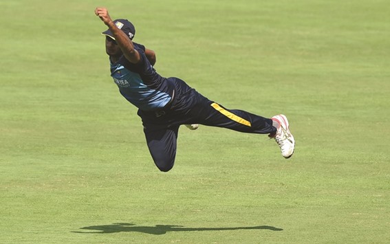 Sri Lankan cricketer Danushka Gunathilaka dives in the air to take a catch during a training session ahead of the T20 international match between India and Sri Lanka at the MCA International Cricket Stadium in Pune.
