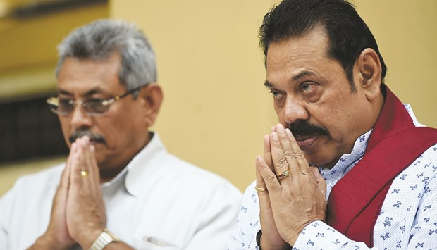 Mahinda Rajapakse, right, and his brother Gotabhaya Rajapakse, pray in Colombo yesterday as they join a petition against a UN-mandated investigation into alleged war crimes during the final stages of the islandu2019s Tamil separatist war.
