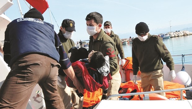 Turkish coastguard personnel carry the body of a boy yesterday off a rescue boat at Altinoluk district, in Balikesir.