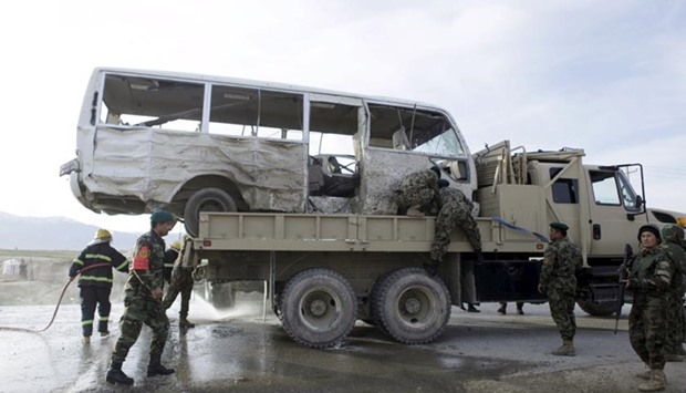 An Afghan National Army truck is used to transport a damaged minibus, which was hit by a suicide attack, on the outskirts of Mazar-i-Sharif on Monday.