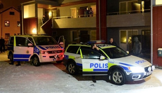 Swedish police stand by police cars outside a house used as a temporary shelter for asylum seekers in Boliden in northeastern Sweden on Nov 19, 2015.