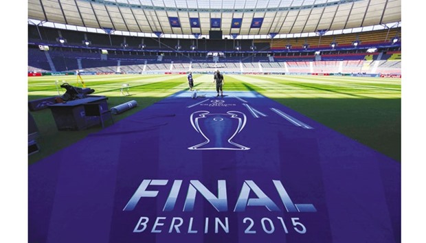 File picture of workers preparing an UEFA Champions League final logo on the pitch at the Olympic stadium.