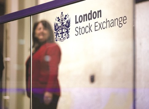 A visitor passes a sign inside the London Stock Exchange. The FTSE 100 closed down 0.88% at 5,639.13 points yesterday.