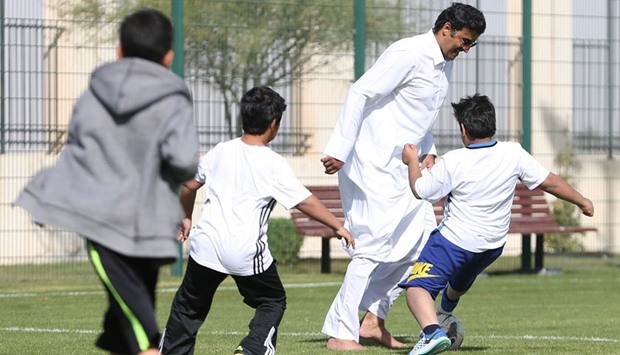 HH the Emir Sheikh Tamim bin Hamad al-Thani during a football match with children yesterday as part of the NSD celebrations