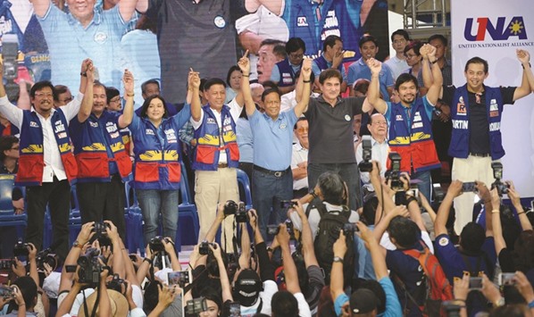 Presidential candidate Jejomar Binay, who is leader of the opposition and current Philippine vice president, his vice-presidential candidate Senator Gringo Honasan (third right), and senatorial line-up led by boxing icon Manny Pacquiao (second right) raise their hands during their partyu2019s proclamation rally in Manila.