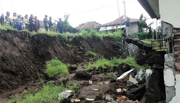 Villagers look at a house which was damaged in a landslide in Kintamani, Bali province, on Friday.