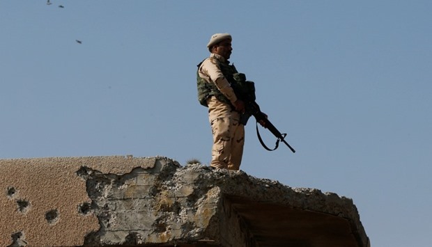 A member of Iraqi security forces stands guard during Friday prayers at the Hajj Diab al-Iraqi mosque in Mosul, Iraq.