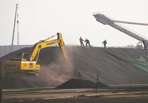 Labourers work on a pile of iron ore at a steel factory in Tangshan, China. Iron ore will probably collapse below $50 a metric tonne in the second half as global supply exceeds demand, according to Liberum Capital, which highlighted prospects for additional output coupled with lacklustre growth in consumption and record port stockpiles in China.
