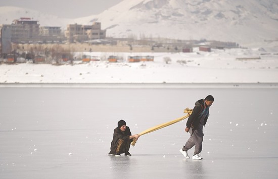 Afghan youths play on the frozen Qargha Lake on the outskirts of Kabul yesterday.