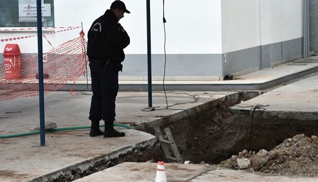 A policeman looks at the hole where an unexploded bomb dating to the World War II was founded