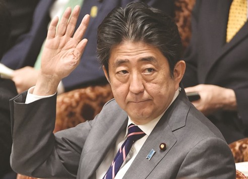 Japanu2019s Prime Minister Shinzo Abe raises a hand to ask permission to answer questions during a budget committee morning session of the House of Representatives at the Diet in Tokyo yesterday. Abe plans to discuss creating jobs and building infrastructure in the US during a meeting with President Donald Trump next week, in a bid to defuse his concerns over trade.