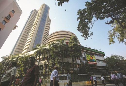 People walk by the Bombay Stock Exchange building in Mumbai. The BSE Sensex closed up 485.68 points to 28,141.64 yesterday.